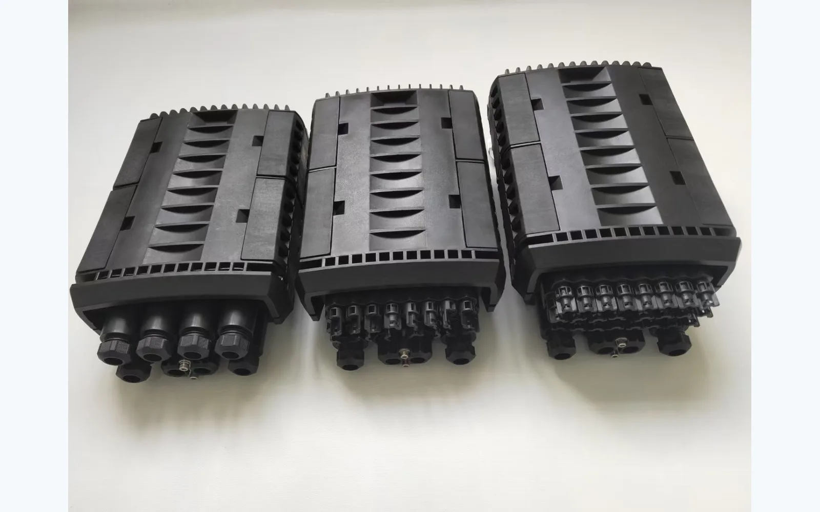 Three fibre closure product samples with different cable-entry arrangements, shown as examples rather than confirmed high-count or ribbon-compatible configurations